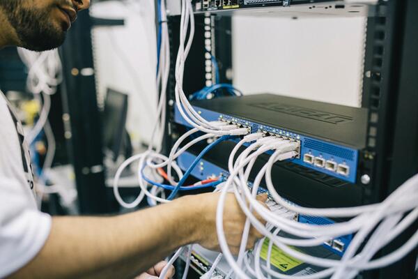 Blick auf einen Serverschrank mit verkabelten Netzwerkkomponenten